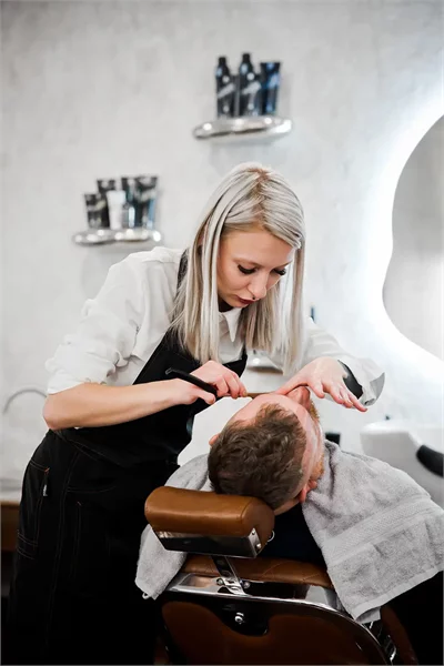 Newman Barber probíhající procedura střihu vlasů